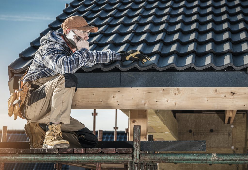 roof-construction-worker-making-phone-call-while-staying-on-scaffolding