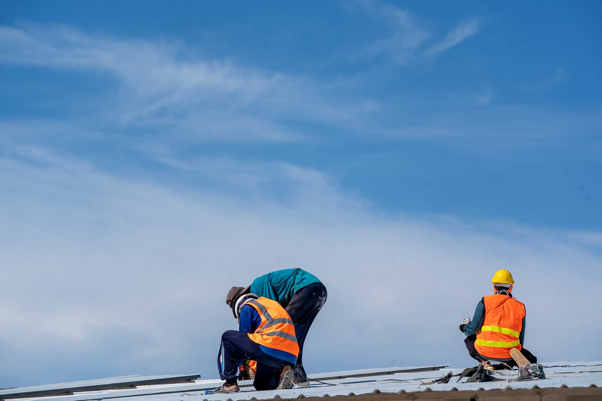 Skilled roofing contractors working on a commercial flat roof installation.